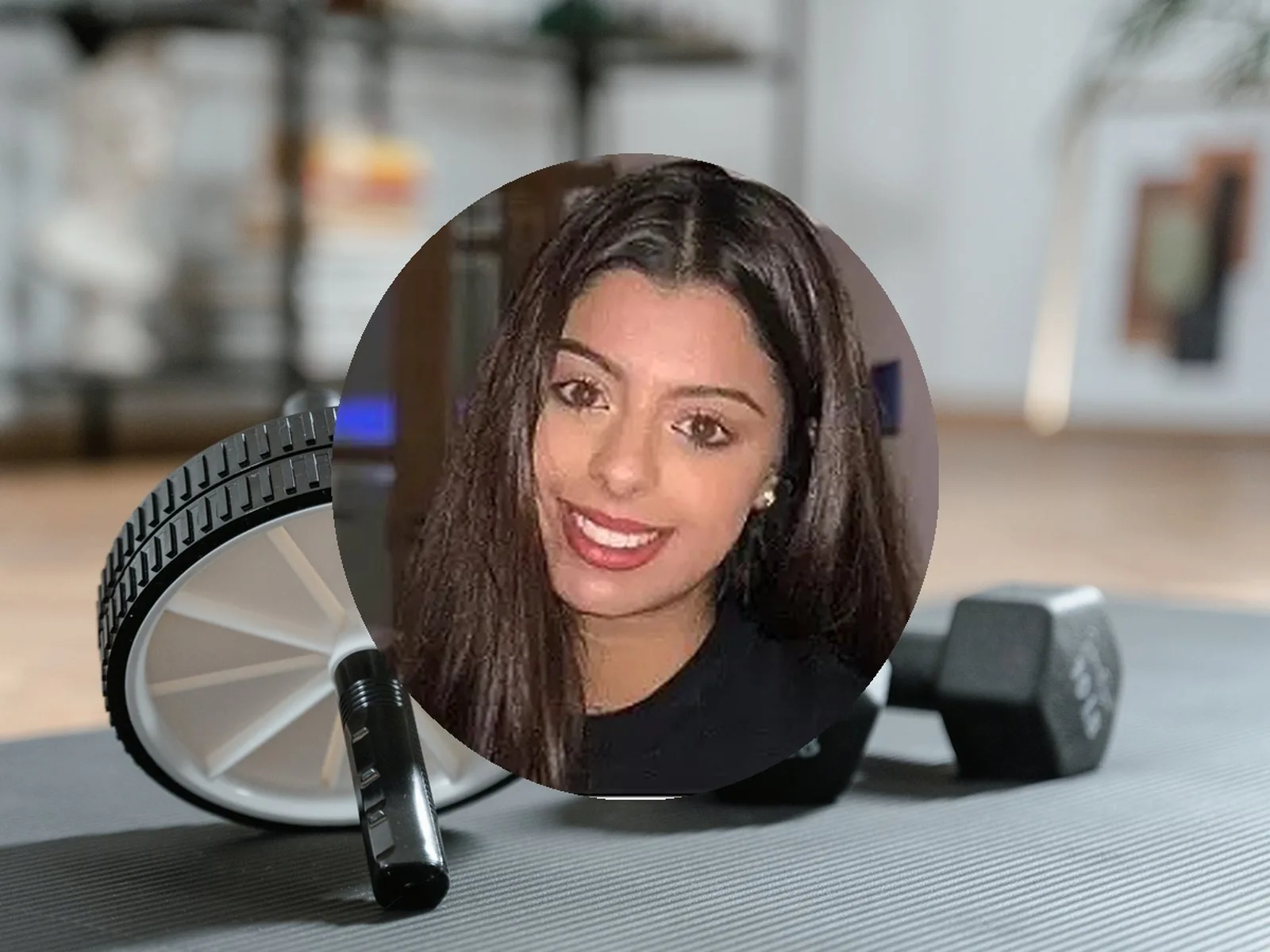 Manisha, a NatFitPT client, in a portrait photo with gym equipment in the background