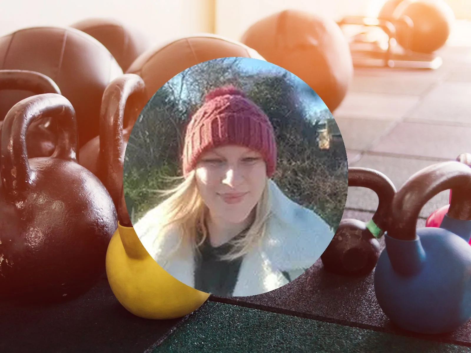 Olivia, a NatFitPT client, in a portrait photo with gym equipment in the background